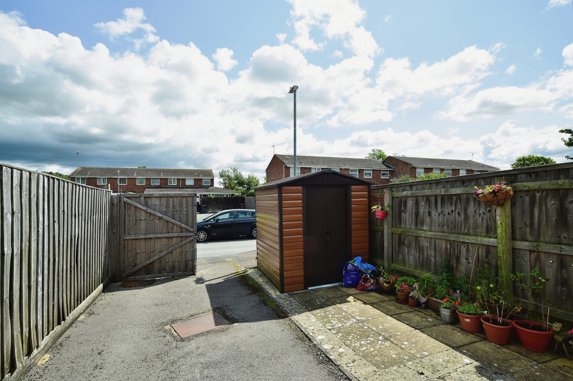 Back garden gate with a shed and space for parking a car