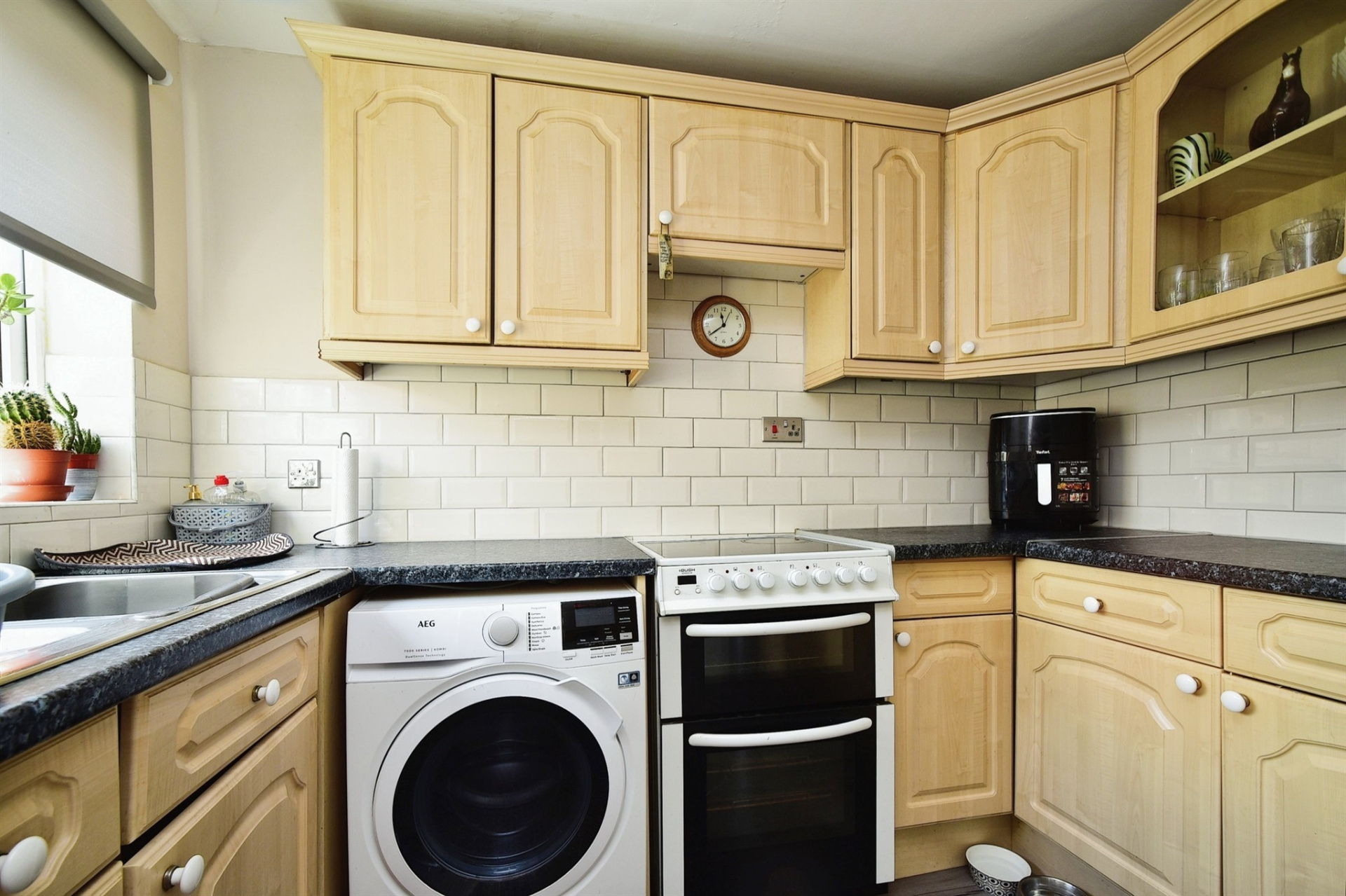 Kitchen with pine units, washing machine, white cooker with white tiled splashback