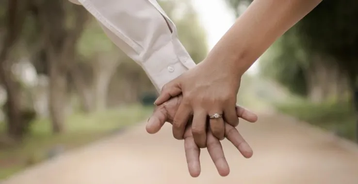 Couple holding hands walking in the park